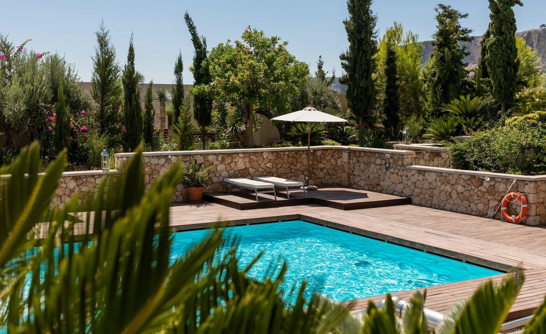Piscina con deck de madera y agua turquesa